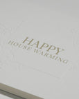 Close-up macro shot highlighting the heavy textured cotton paper and fine gold metallic lettering on the Vaucluse luxury housewarming card.