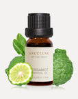 A 10ml amber glass bottle of Vaucluse Bergamot Essential Oil backed by a whole wrinkled green bergamot fruit and a fresh citrus slice.