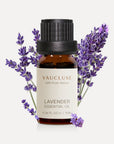 A 10ml amber glass bottle of Vaucluse Lavender Essential Oil accented with fresh purple lavender flower sprigs in the background.