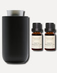Two 10ml Vaucluse Peach and Grapefruit Tea essential oil bottles next to a matte black aroma diffuser.
