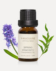 A 10ml amber glass bottle of Vaucluse Spring Hyacinth Essential Oil, flanked by a purple hyacinth flower stalk and a green serrated leaf.