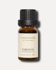 A clean front view studio shot of a 10ml amber glass bottle of Vaucluse Tuberose Essential Oil with a textured black cap.