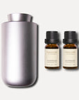A sleek purple dusk waterless nebulizing diffuser shown alongside two 10ml amber bottles of premium agarwood essential oil.