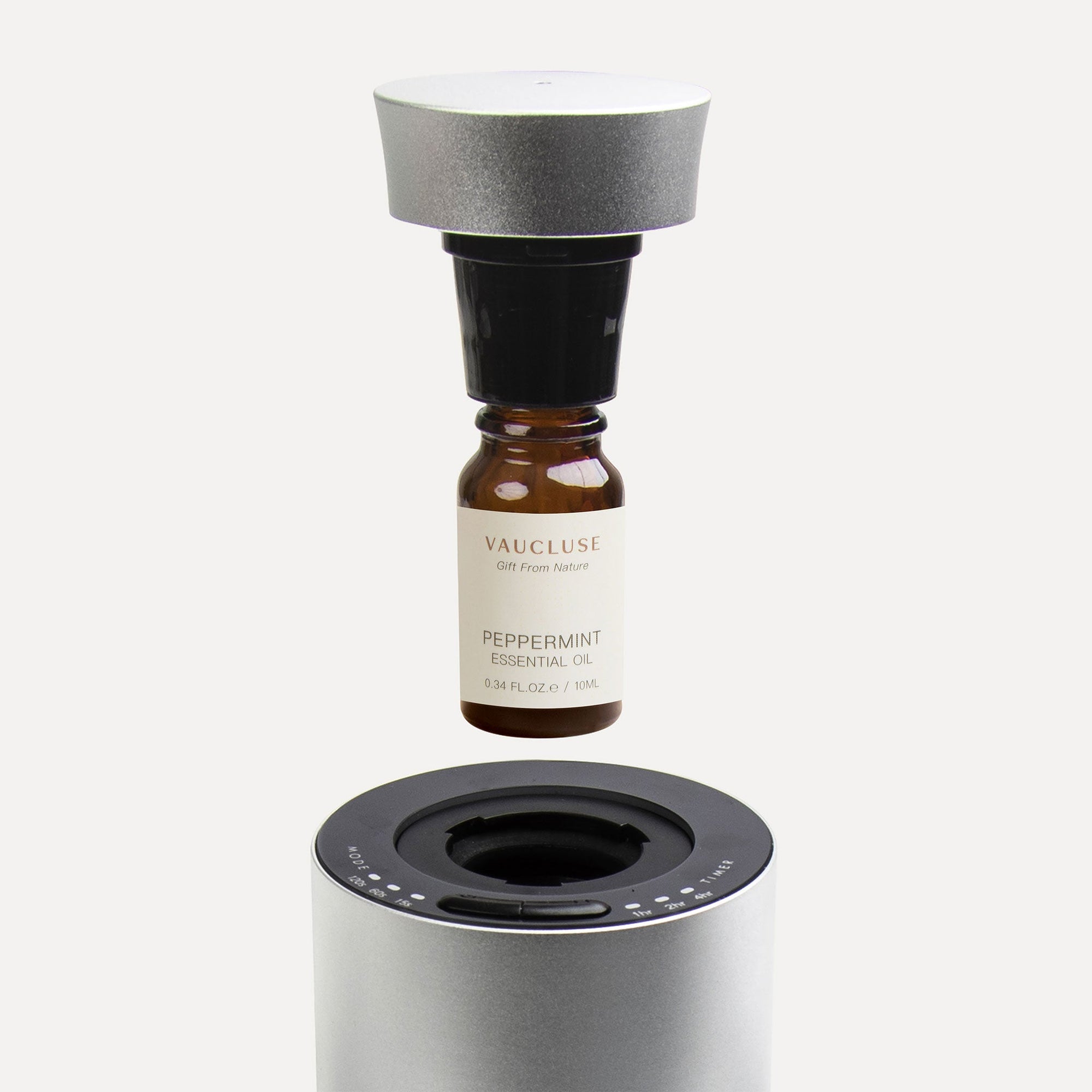 An instructional graphic showing a 10ml Vaucluse amber oil bottle screwing directly into a black adapter cap above a silver waterless aroma diffuser.