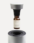 An instructional graphic showing a 10ml Vaucluse amber oil bottle screwing directly into a black adapter cap above a silver waterless aroma diffuser.