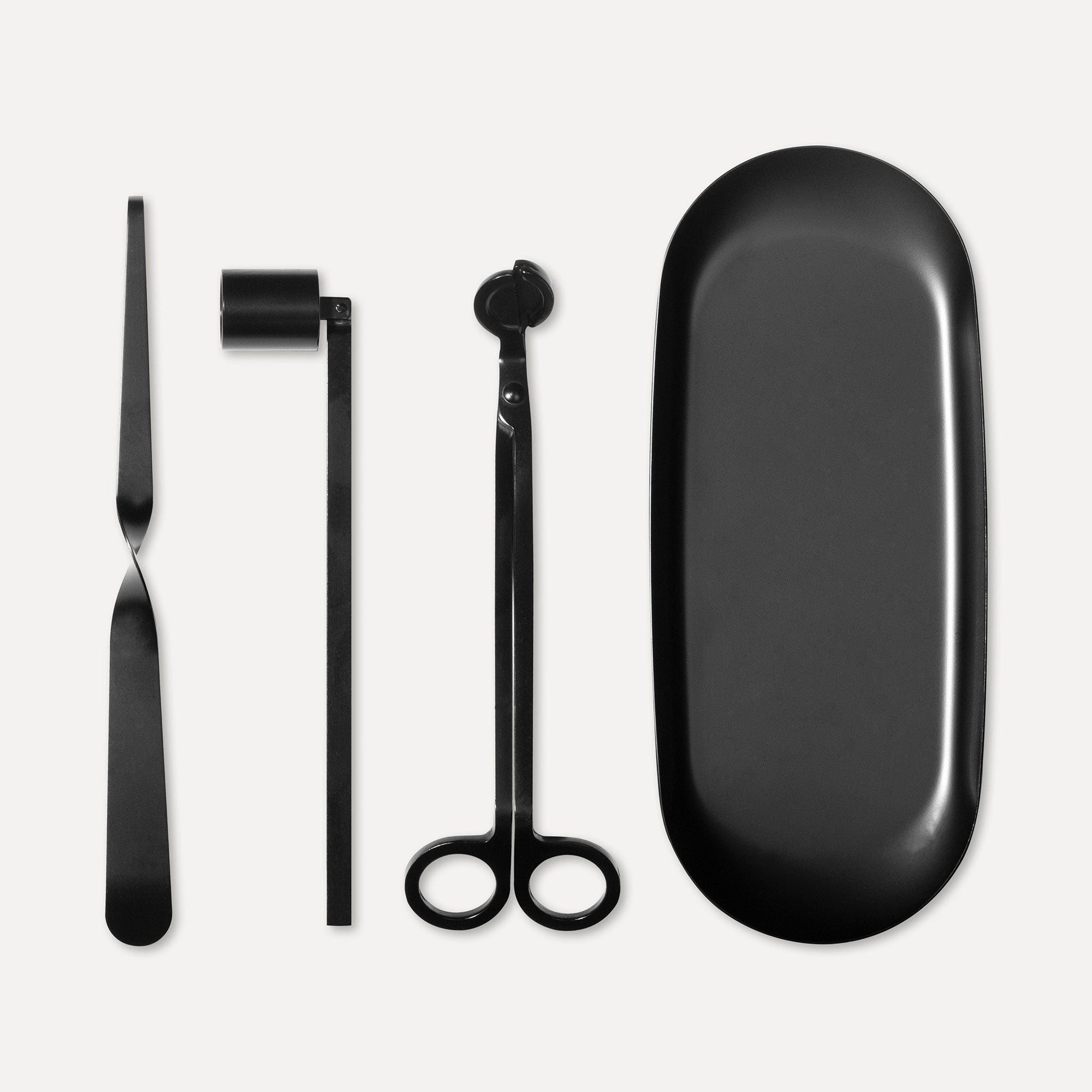 Matte black candle care accessory set featuring a wick trimmer, candle snuffer, wick dipper, and matching oval tray on a clean white background.