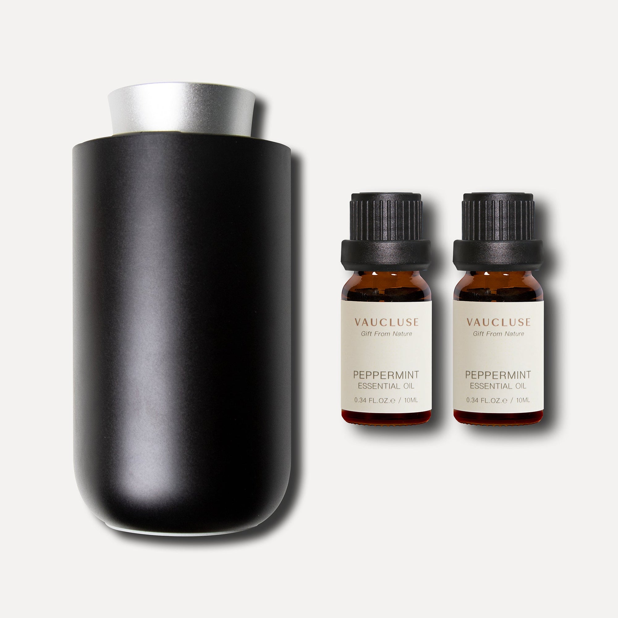 A sleek matte black waterless nebulizing diffuser presented alongside two 10ml bottles of Vaucluse Peppermint Essential Oil.