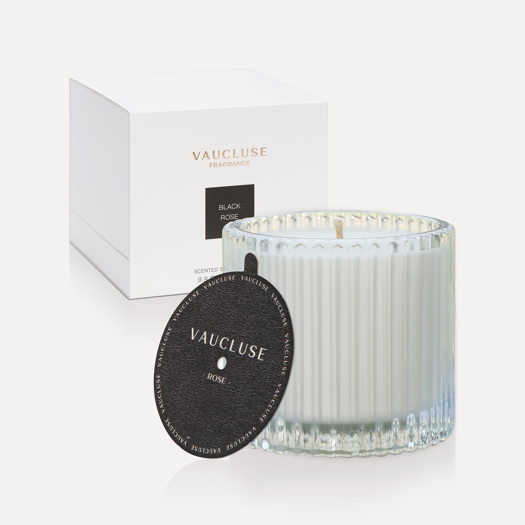 Vaucluse Black Rose luxury scented soy wax candle in a clear ribbed glass jar displayed next to its textured black dust cover lid and minimalist white gift box.