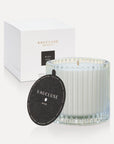 Vaucluse Black Rose luxury scented soy wax candle in a clear ribbed glass jar displayed next to its textured black dust cover lid and minimalist white gift box.