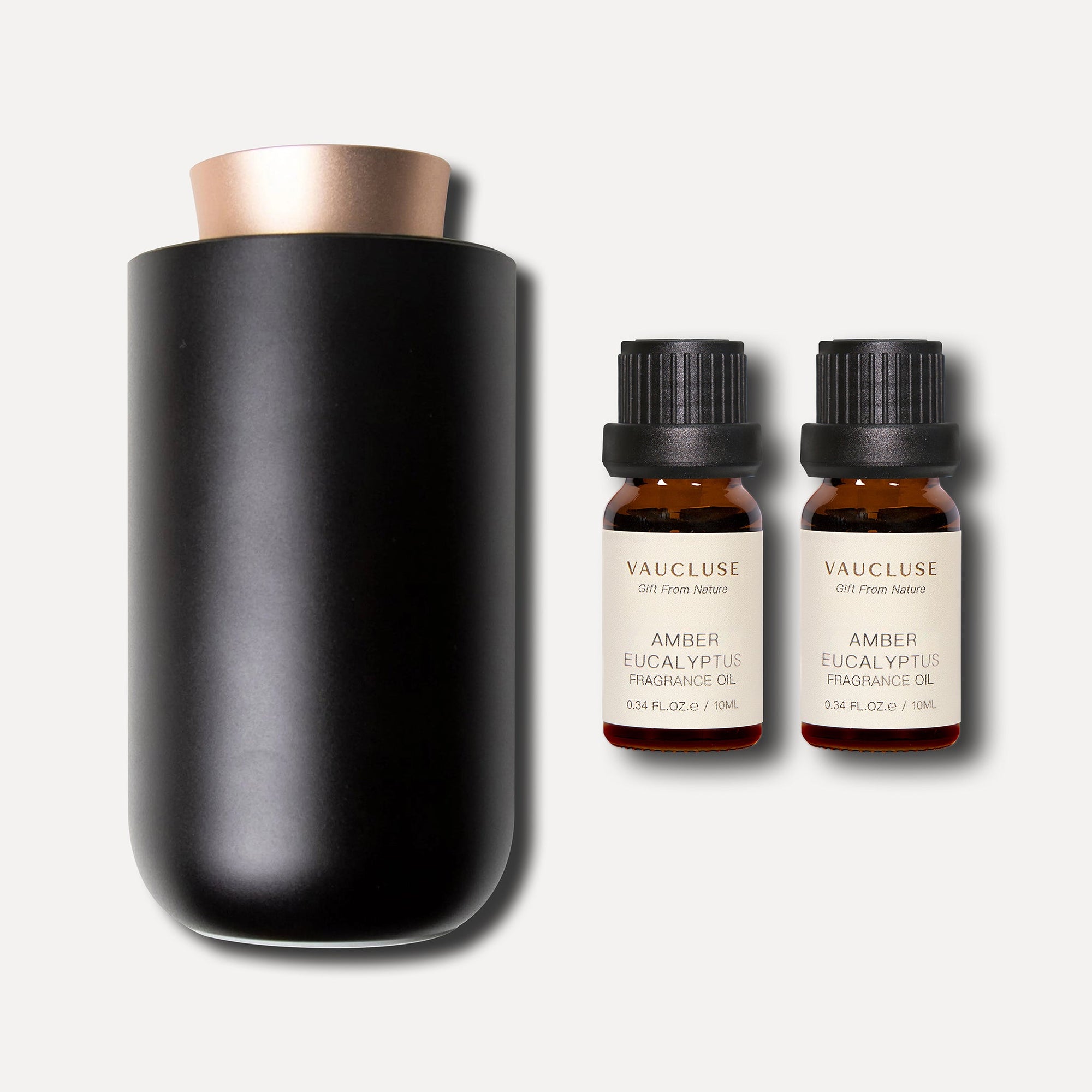 A minimalist black waterless aroma diffuser displayed alongside two 10ml bottles of Vaucluse Amber Eucalyptus Essential Oil.