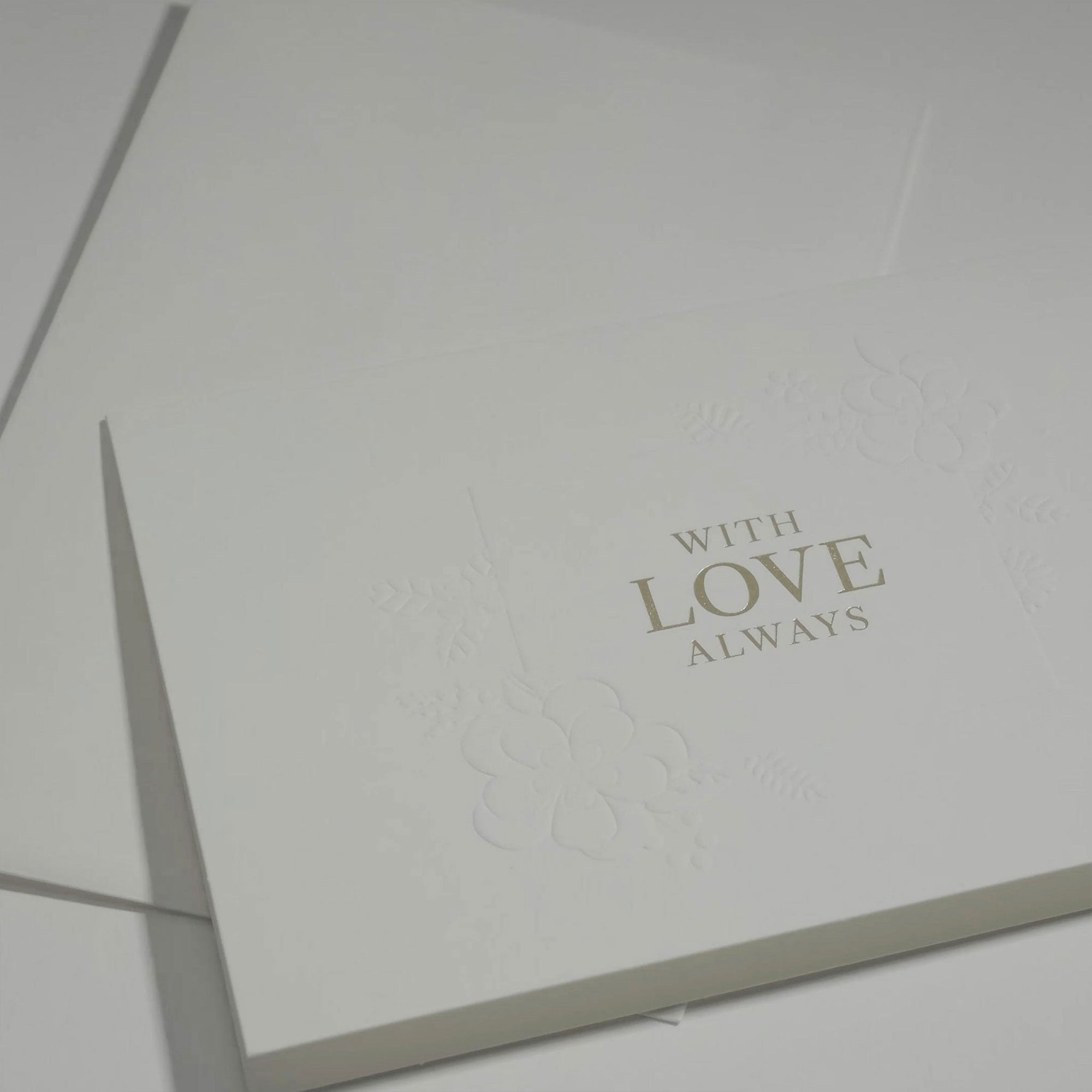 Side angle close-up emphasizing the clean typography and premium blind-embossed floral framework on a luxury love and anniversary greeting card.