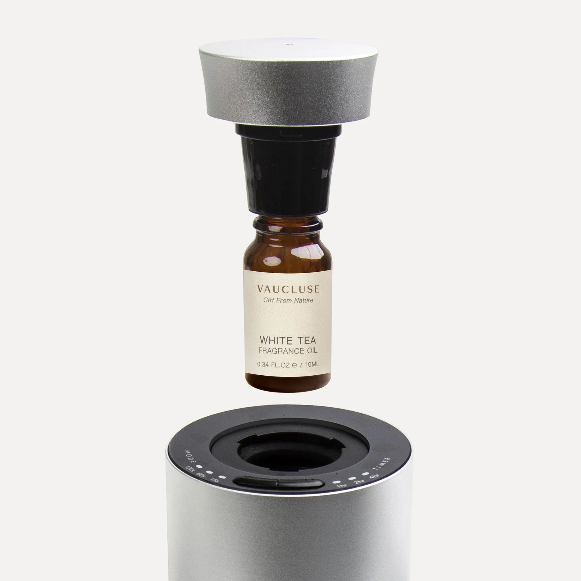 An explanatory view showing a 10ml oil bottle attached to a silver nozzle cap as it hovers above the top slot of a waterless aroma diffuser.