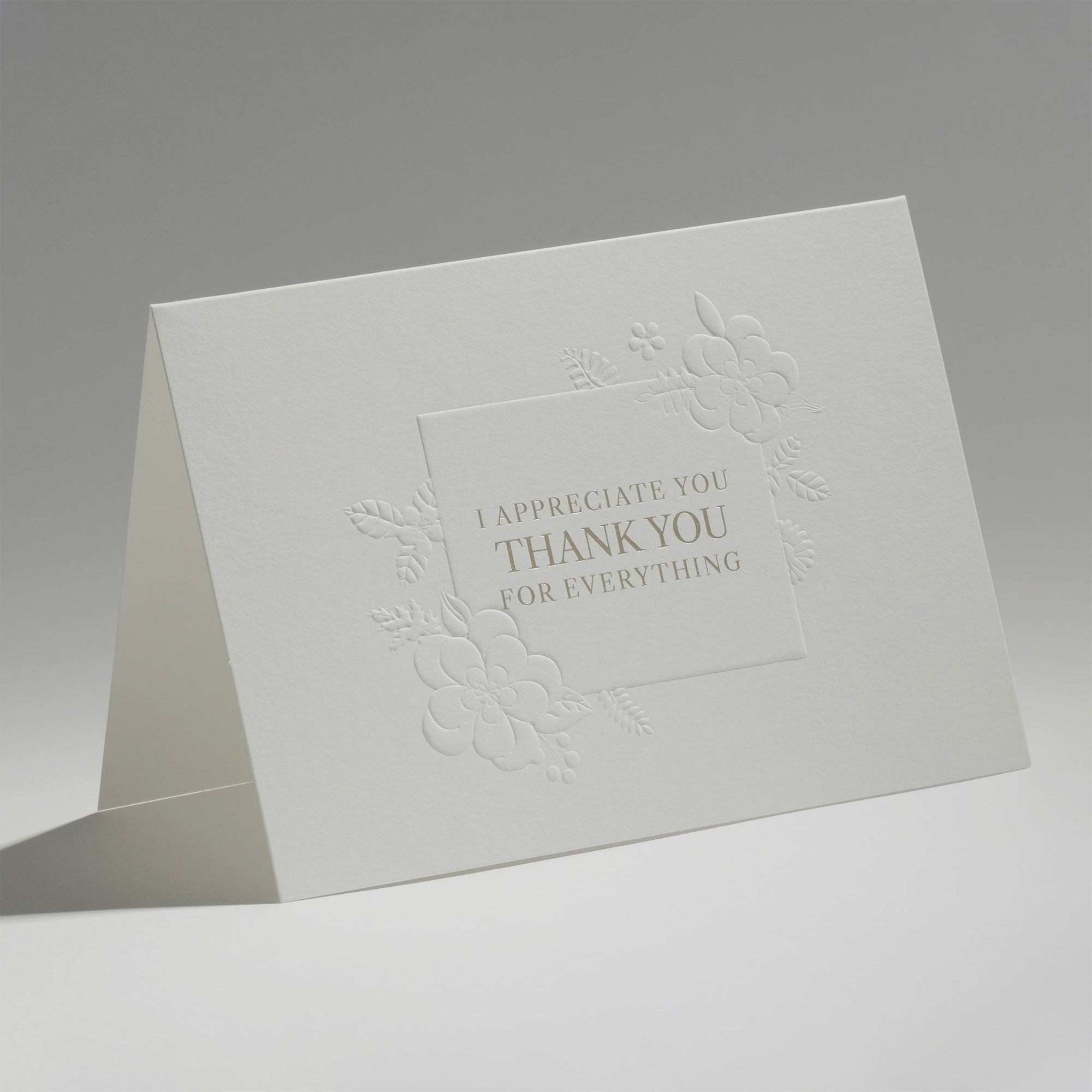 An elegant, freestanding white thank you card featuring debossed floral motifs surrounding the text "I Appreciate You, Thank You For Everything."