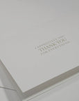 Side angle close-up emphasizing the crisp, clean typography and elegant floral embossing framework on a luxury white appreciation card.