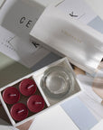 Aesthetic top-down view of the premium berry scented tealight candle gift box arranged over modern minimalist design books.