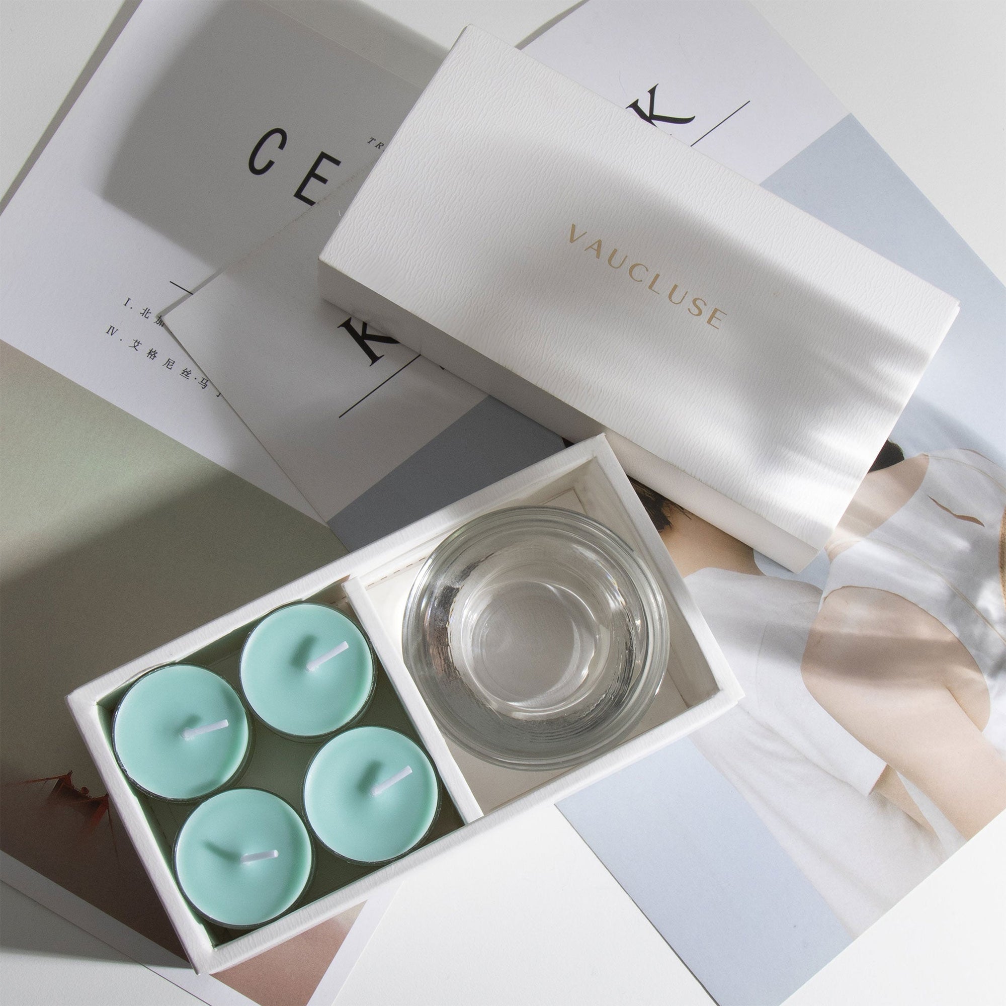 Aesthetic top-down view of the premium ocean scented tealight candle gift set laid out across white minimalist magazines.