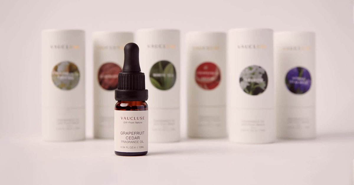 Vaucluse Fragrance premium quality essential oils collection featuring a Grapefruit Cedar fragrance oil dropper bottle in front of white minimalist cylindrical product packaging