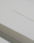 Close-up macro view highlighting the rich textured paper and fine gold metallic embossing on the Vaucluse luxury congratulations card.
