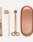 Premium rose gold candle care accessory set featuring a wick trimmer, candle snuffer, wick dipper, and matching oval tray on a clean background.
