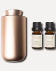 A metallic rose gold waterless nebulizing aroma diffuser displayed beside two 10ml Vaucluse amber bottles of spring hyacinth essential oil.