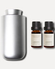 A sleek silver waterless nebulizing aroma diffuser displayed with two 10ml amber bottles of Vaucluse lavender essential oil.