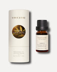 A 10ml amber bottle of Vaucluse Amber Eucalyptus Essential Oil next to its cream-colored cylindrical cardboard packaging tube featuring a round metallic icon.