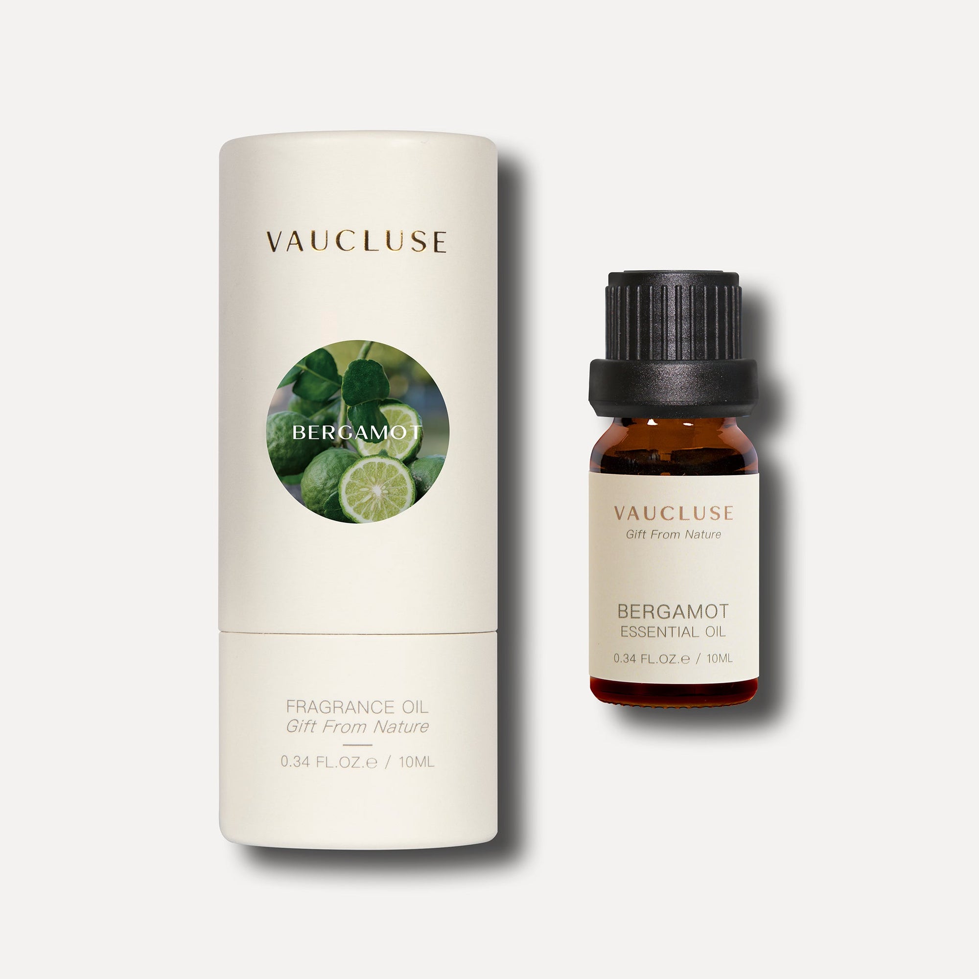 A 10ml amber bottle of Vaucluse bergamot essential oil standing beside its white cylindrical protective packaging tube.