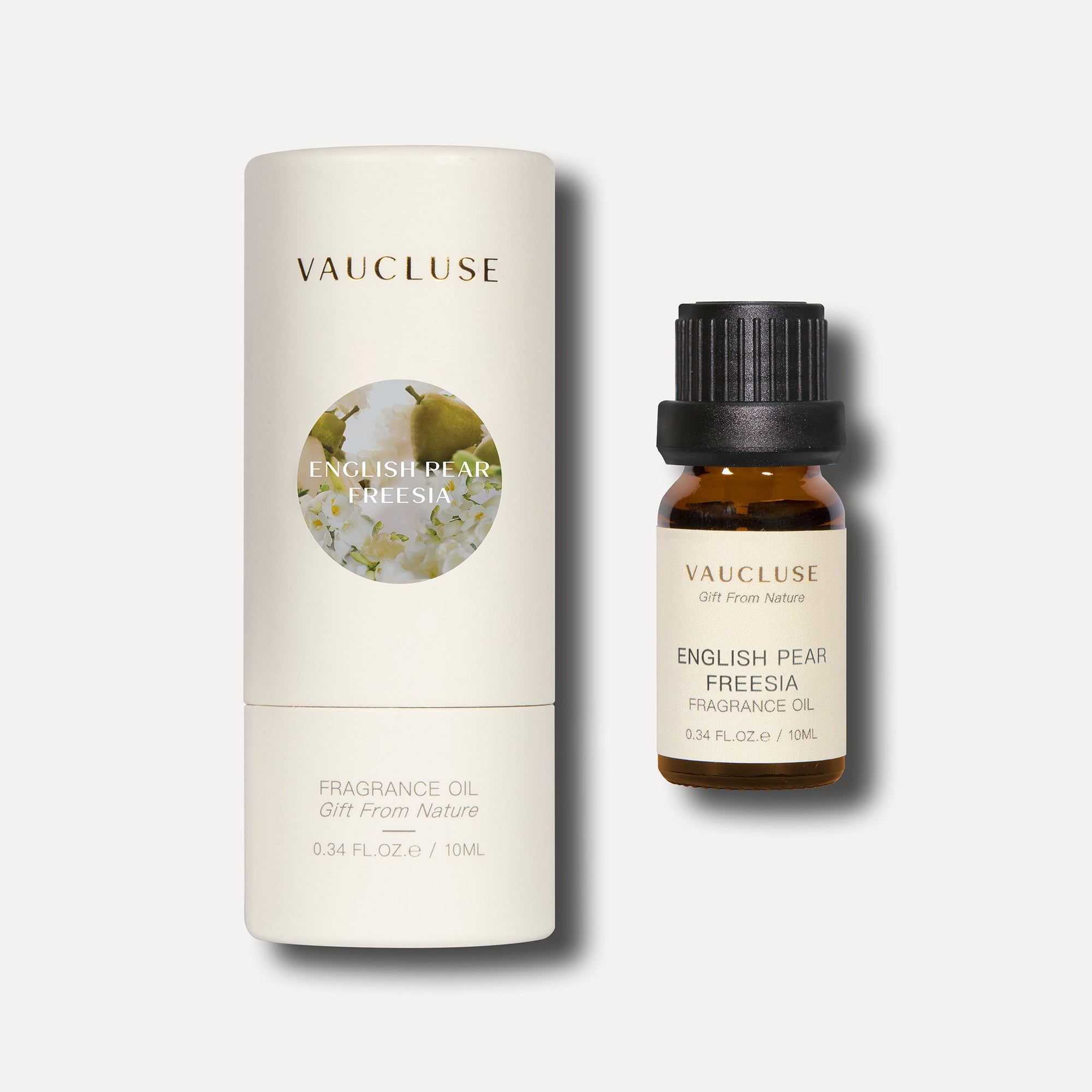 A 10ml bottle of English pear and freesia essential oil standing next to its protective white cylindrical tube box packaging.