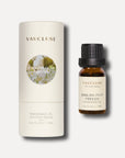 A 10ml bottle of English pear and freesia essential oil standing next to its protective white cylindrical tube box packaging.