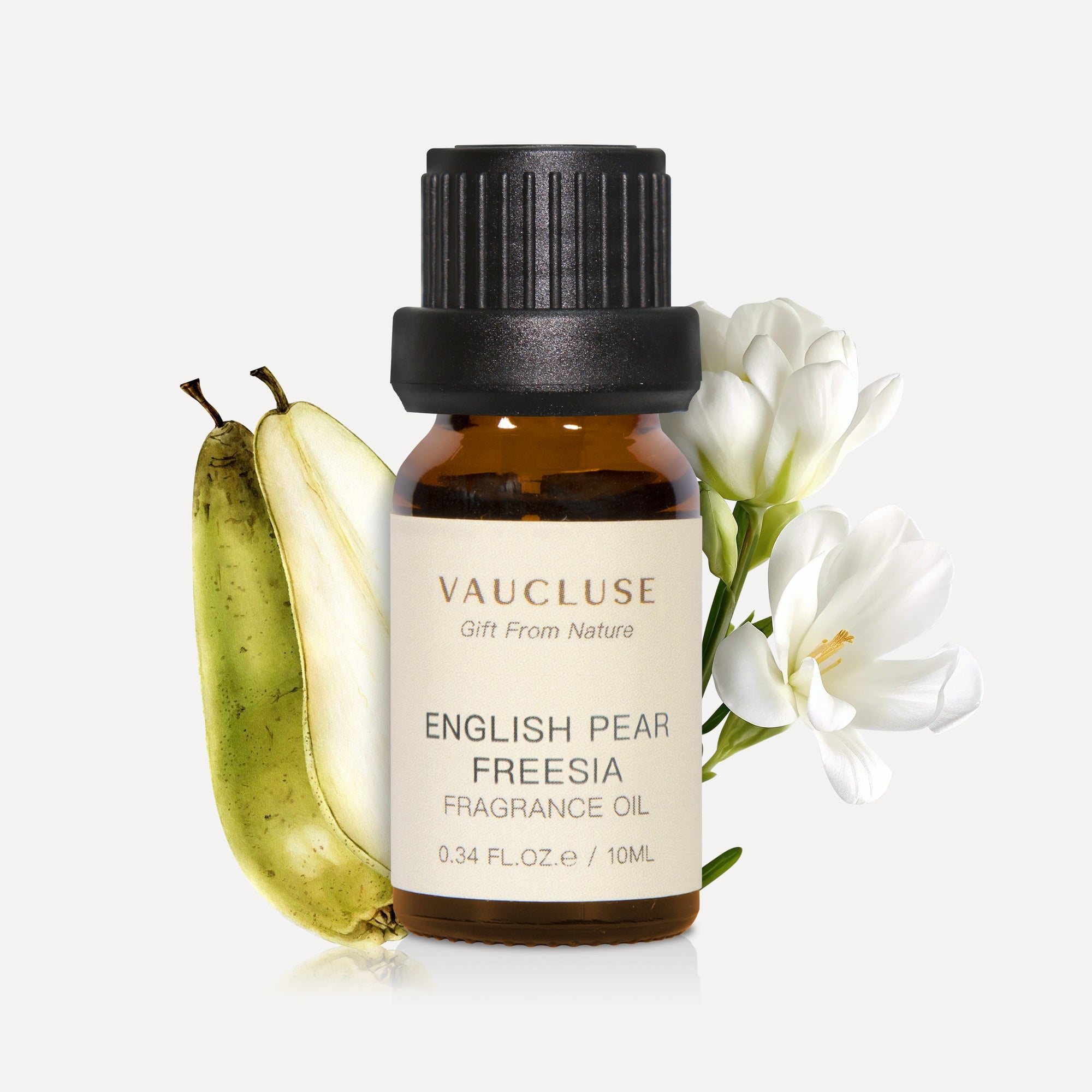 A 10ml amber glass bottle of Vaucluse English Pear and Freesia Essential Oil, flanked by a sliced green pear and elegant white freesia flowers.