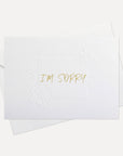Front view of a minimalist white Vaucluse "I'm Sorry" apology greeting card resting on its matching white paper envelope.
