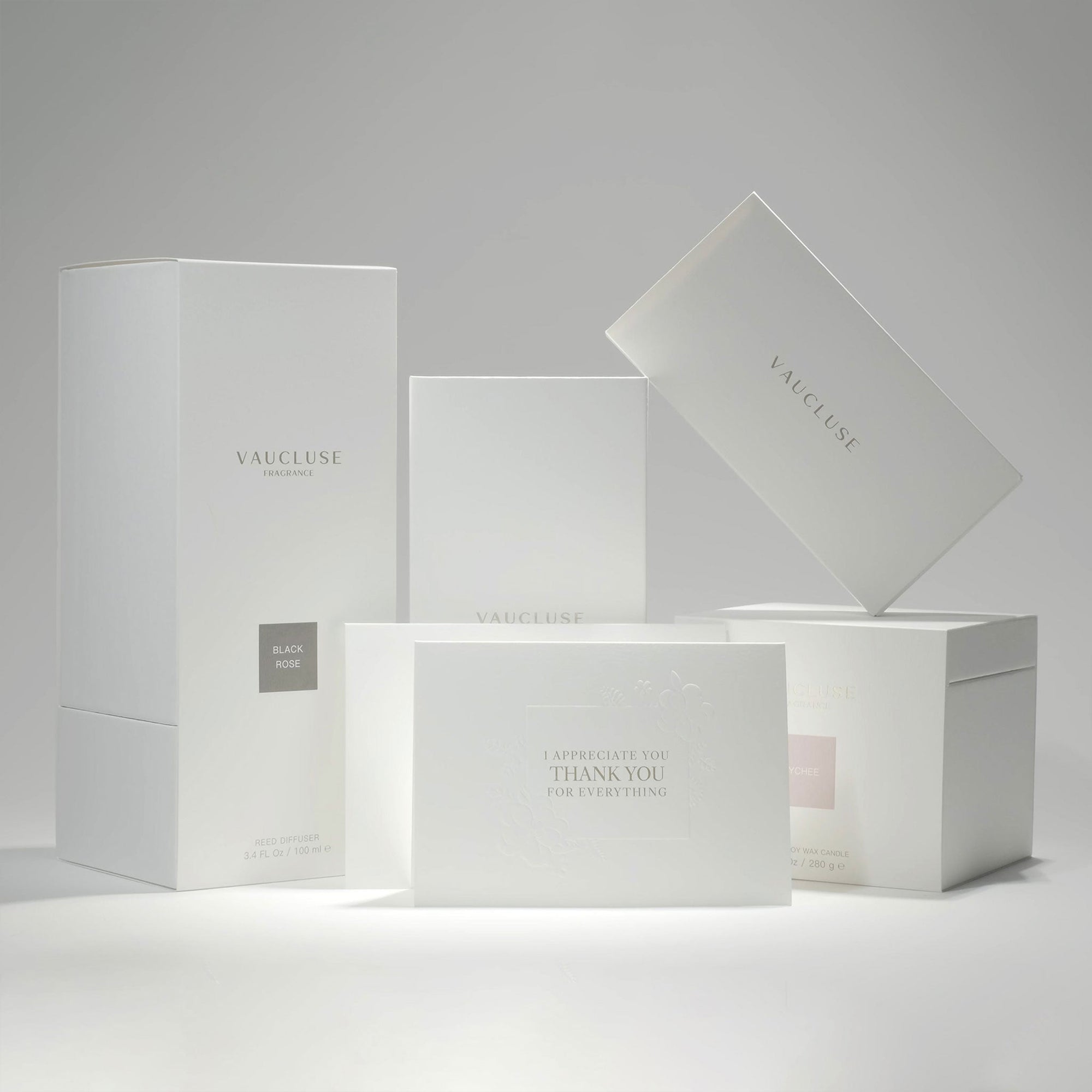A collection of premium minimalist white Vaucluse fragrance gift boxes, candle packaging, and the "I Appreciate You" card neatly styled on a white surface.