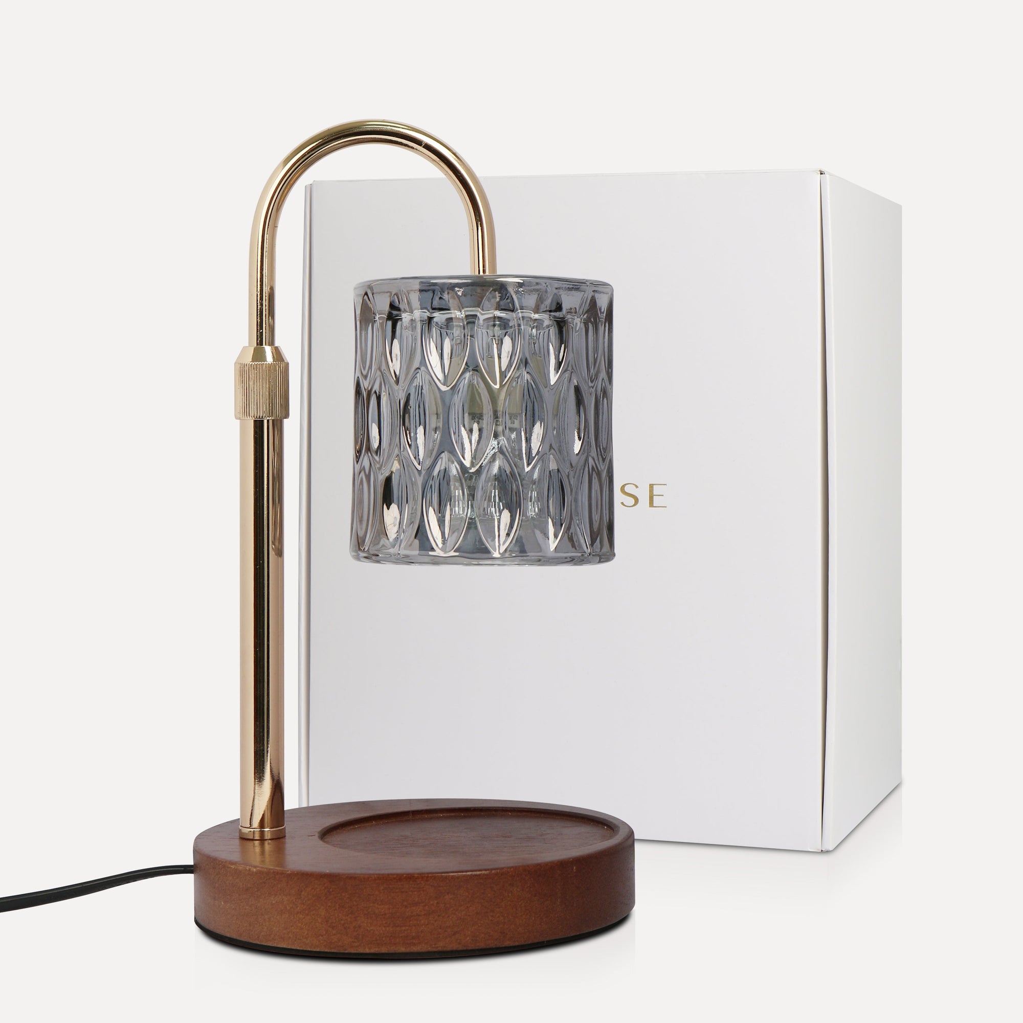 Vaucluse Fragrance luxury smoky grey crystal candle warmer lamp with a charcoal-tinted glass shade, curved gold neck, and wood base beside its white product box.