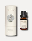 A 10ml bottle of Vaucluse gardenia essential oil standing next to its round white cylindrical container package.