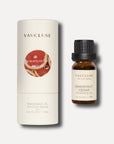 A 10ml amber bottle of Vaucluse grapefruit cedar fragrance oil sitting next to its white cylindrical packaging box.