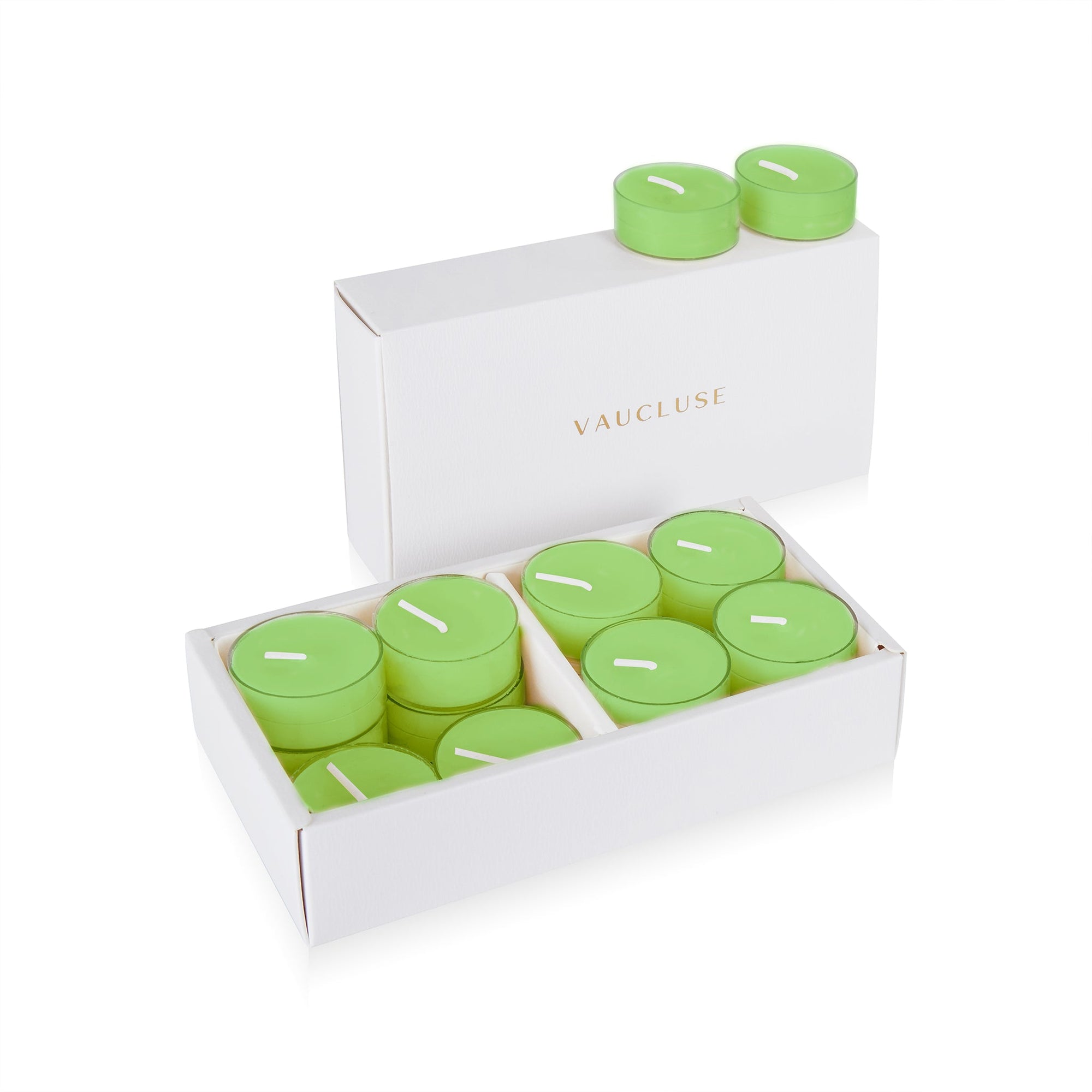 An open luxury white Vaucluse box set displaying premium light green lily scented tealight candles arranged in a tiered 16-pack tray.