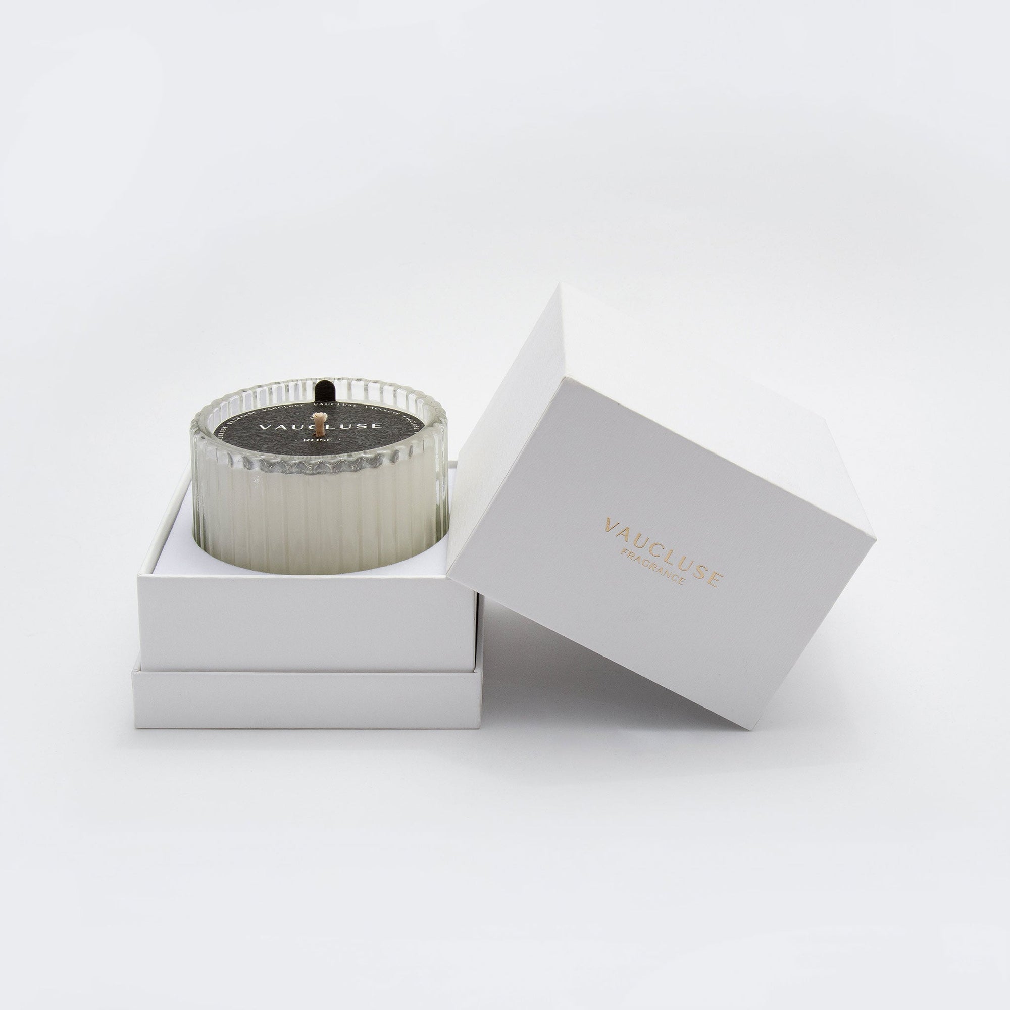 A Vaucluse Black Rose scented candle resting inside its custom white, two-piece premium gift box with the lid elegantly propped open.