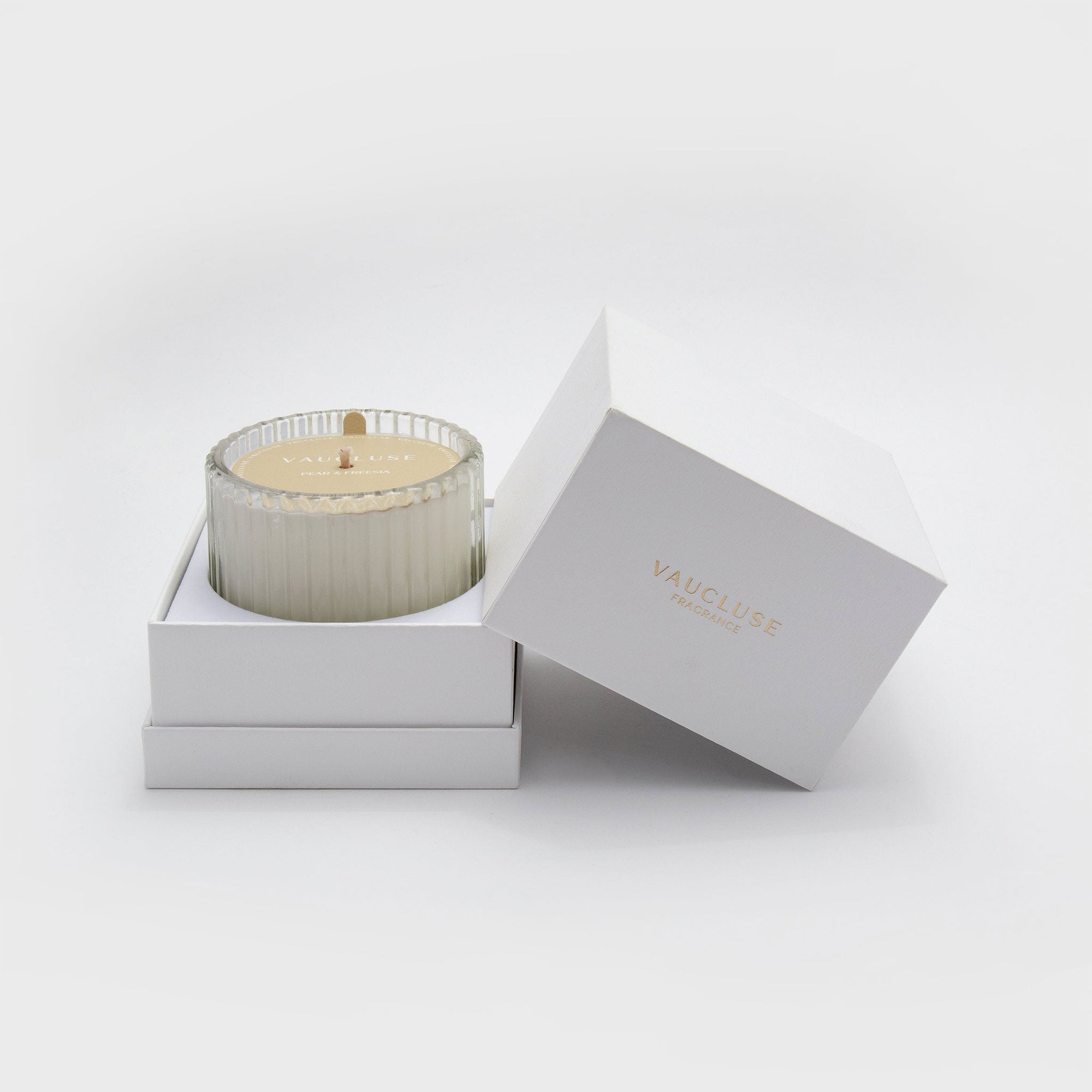Premium unboxing experience showing a Vaucluse soy wax candle sitting inside its custom two-piece white luxury gift box container.