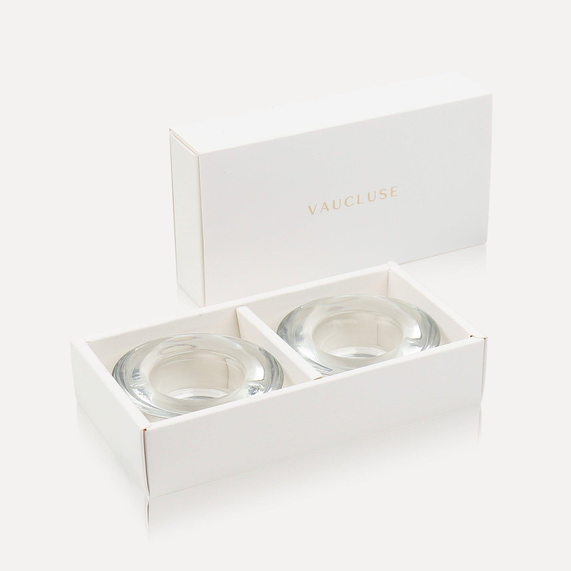 Two premium clear glass tealight candle holders safely displayed inside an open minimalist luxury white gift box featuring gold Vaucluse branding.