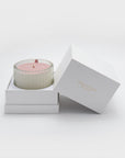 A Vaucluse Lychee scented candle with pink lid resting inside its premium white two-piece gift box with the lid open.