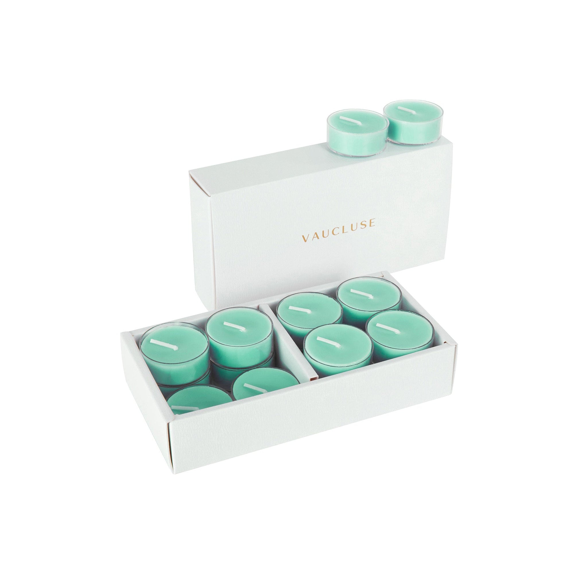 An open luxury white Vaucluse gift box showcasing a premium 16-pack set of light teal ocean scented tealight candles.
