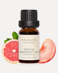 Vaucluse 10ml Peach and Grapefruit Tea essential oil amber bottle styled with fresh grapefruit and peach slices.