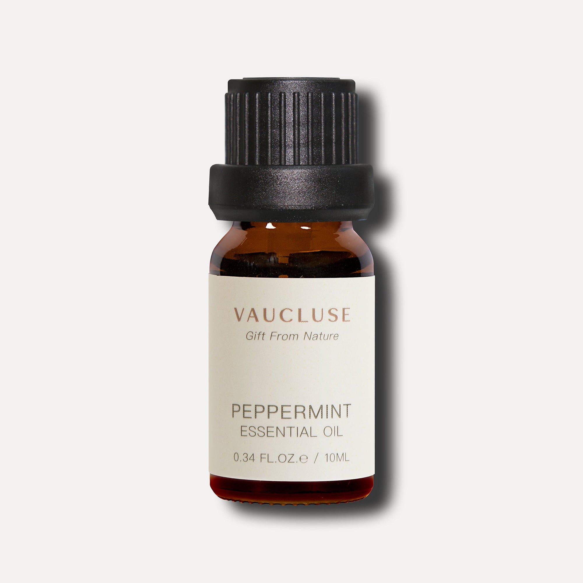A clean studio product shot of a 10ml amber glass bottle of Vaucluse Peppermint Essential Oil against a solid light gray background.