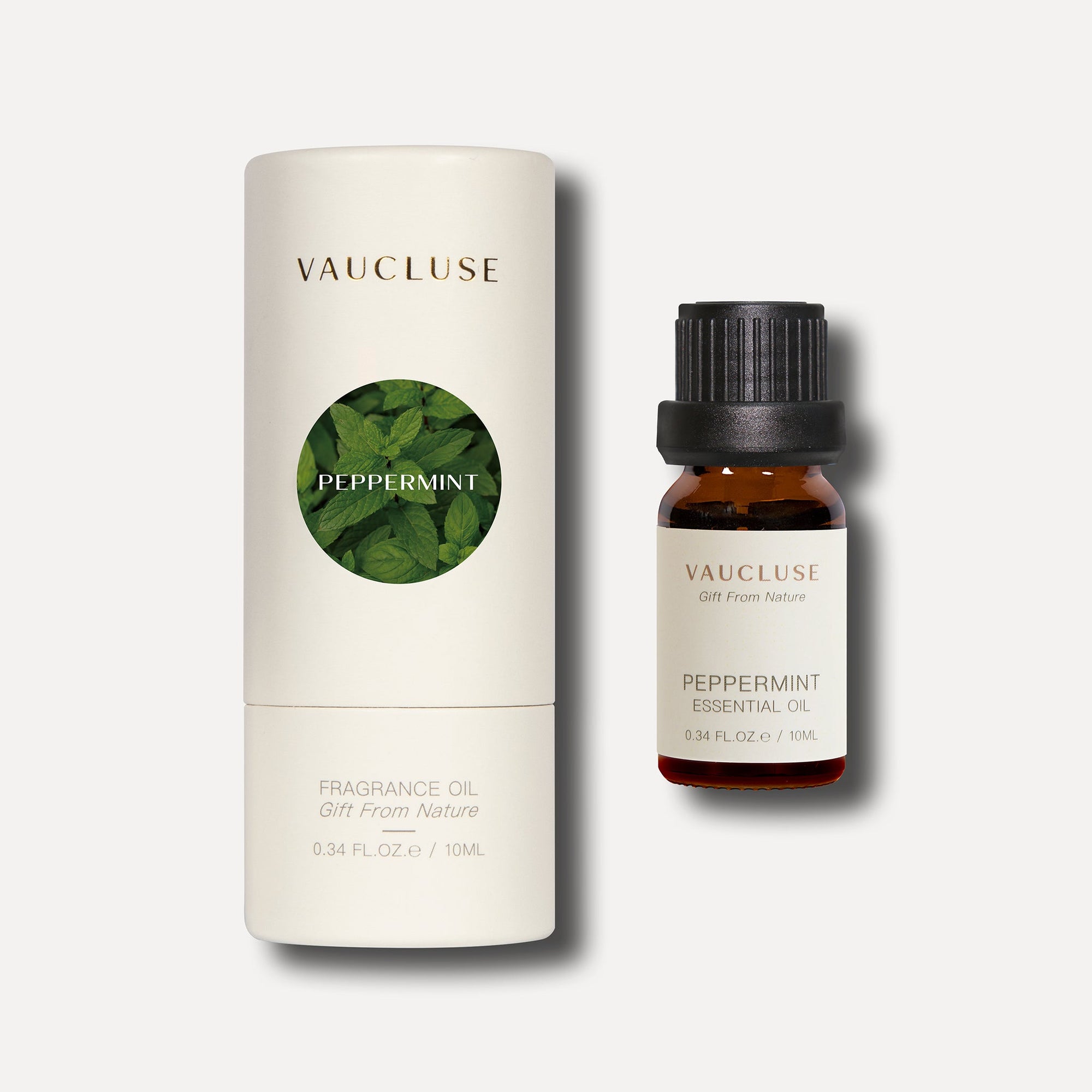 A 10ml bottle of Vaucluse Peppermint Essential Oil standing next to its premium cream-colored cylindrical cardboard packaging tube.