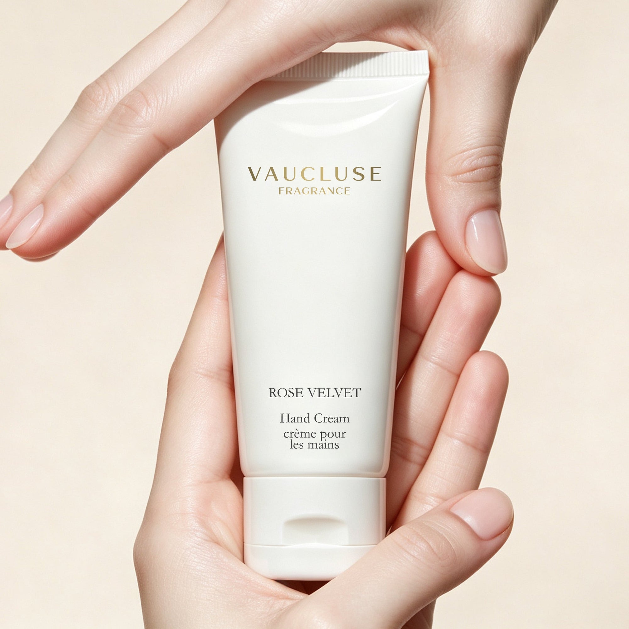 Hands gently framing a tube of Vaucluse Fragrance Rose Velvet luxury hand lotion.