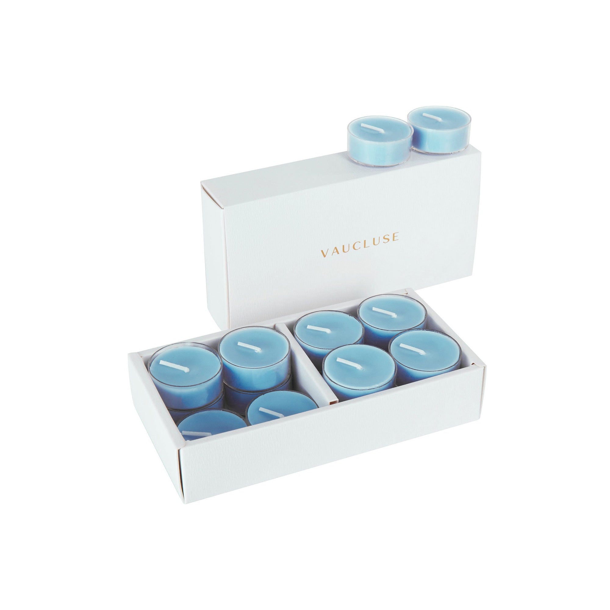 An open luxury white Vaucluse box set displaying premium light blue sea breeze scented tealight candles arranged in a tiered 16-pack tray.