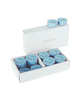 An open luxury white Vaucluse box set displaying premium light blue sea breeze scented tealight candles arranged in a tiered 16-pack tray.