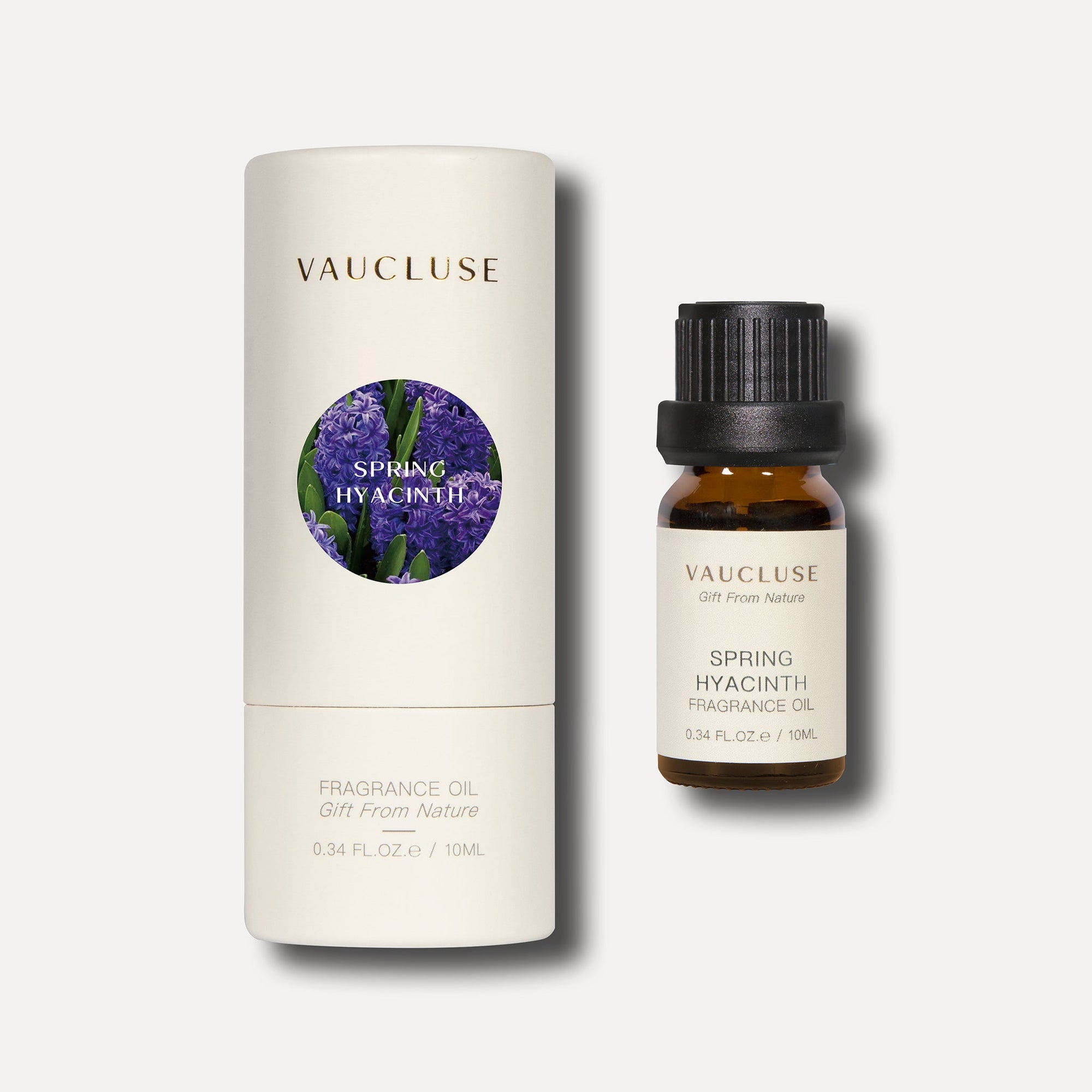 A 10ml amber bottle of Vaucluse spring hyacinth essential oil next to its matching white cylindrical tube packaging box.