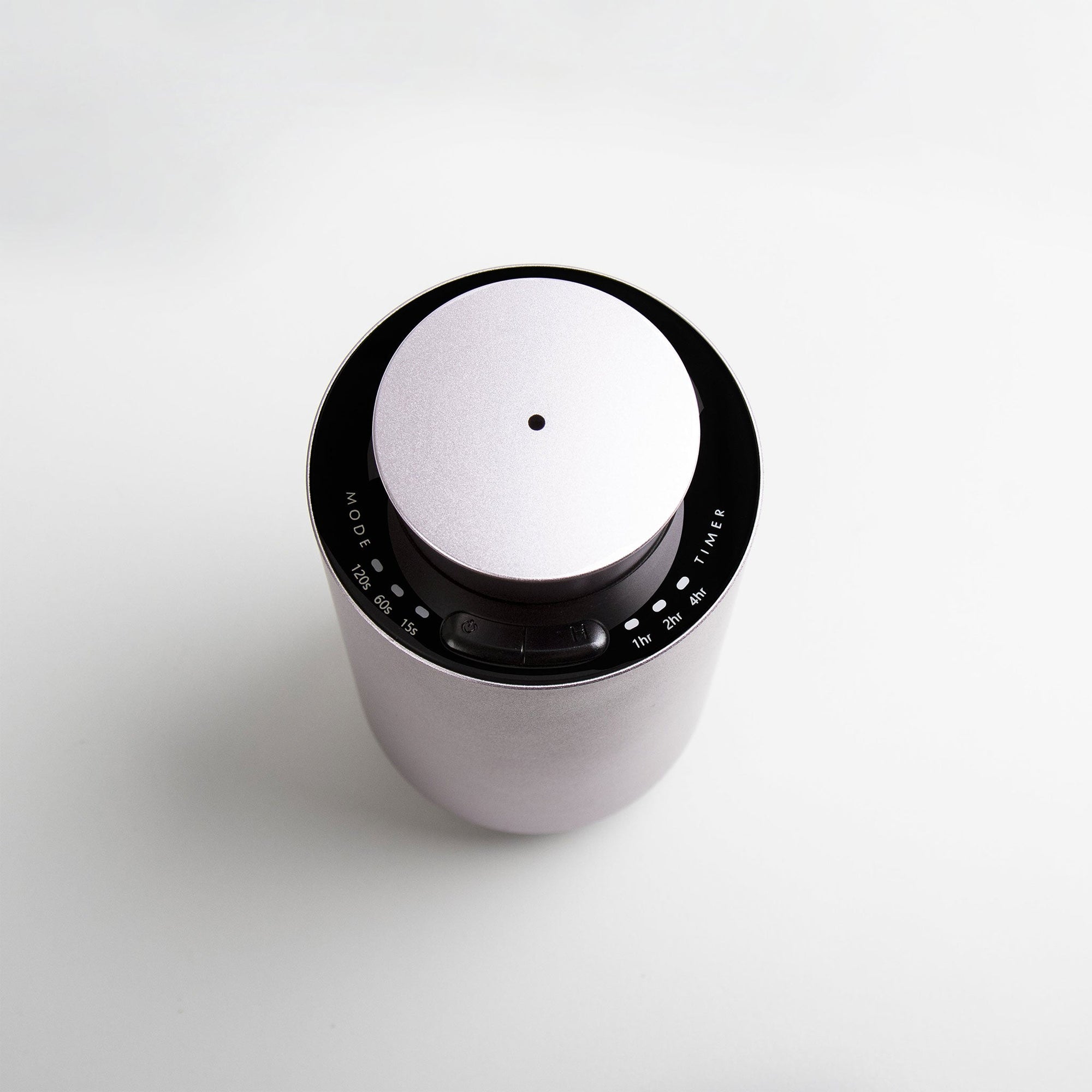 A high-angle top-down view of the circular purple dusk waterless diffuser showcasing the central mist output nozzle and clean touch controls.